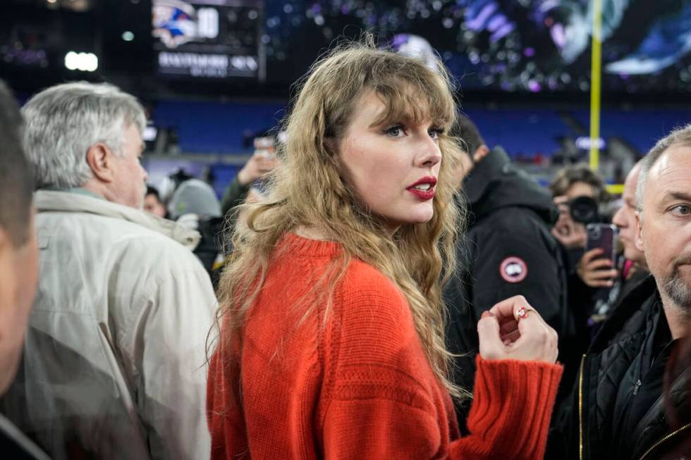 Taylor Swift speaks with people on the field after an AFC Championship NFL football game betwee ...
