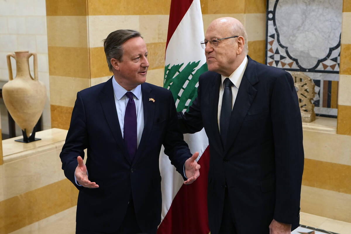Britain's Foreign Secretary David Cameron, left, speaks with Lebanese caretaker Prime Minister ...