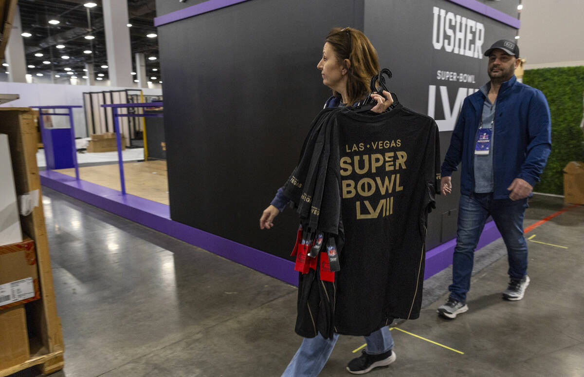 T-shirts for sale are brought in within the NFL Shop being set up for the Super Bowl Experience ...