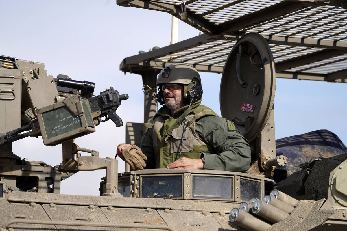 An Israeli soldier drives in an armored vehicle in southern Israel near the border with the Gaz ...