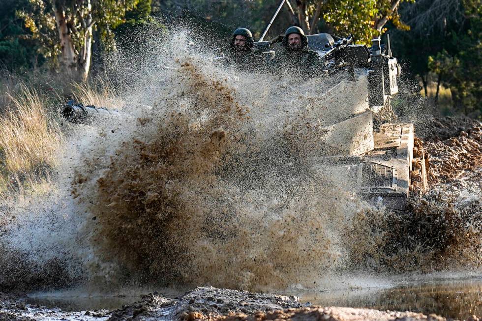 Israeli soldiers drive a tank on the border with the Gaza Strip, as seen from southern Israel, ...