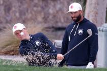 Jon Rahm, right, watches Caleb Surratt's hit during practice before the LIV Golf Las Vegas tour ...