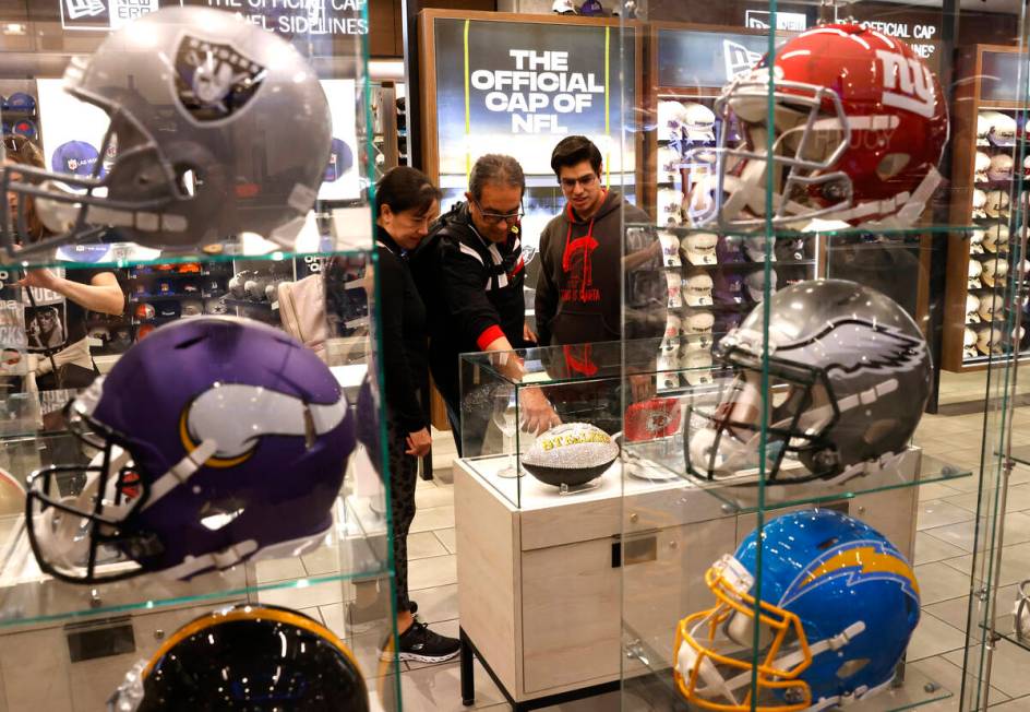 Shoppers check out Super Bowl LVIII merchandise at the NFL Las Vegas store at the Forum Shop, o ...
