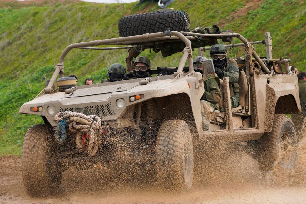 Israeli soldiers drive near the border with the Gaza Strip, as seen in southern Israel, Tuesday ...