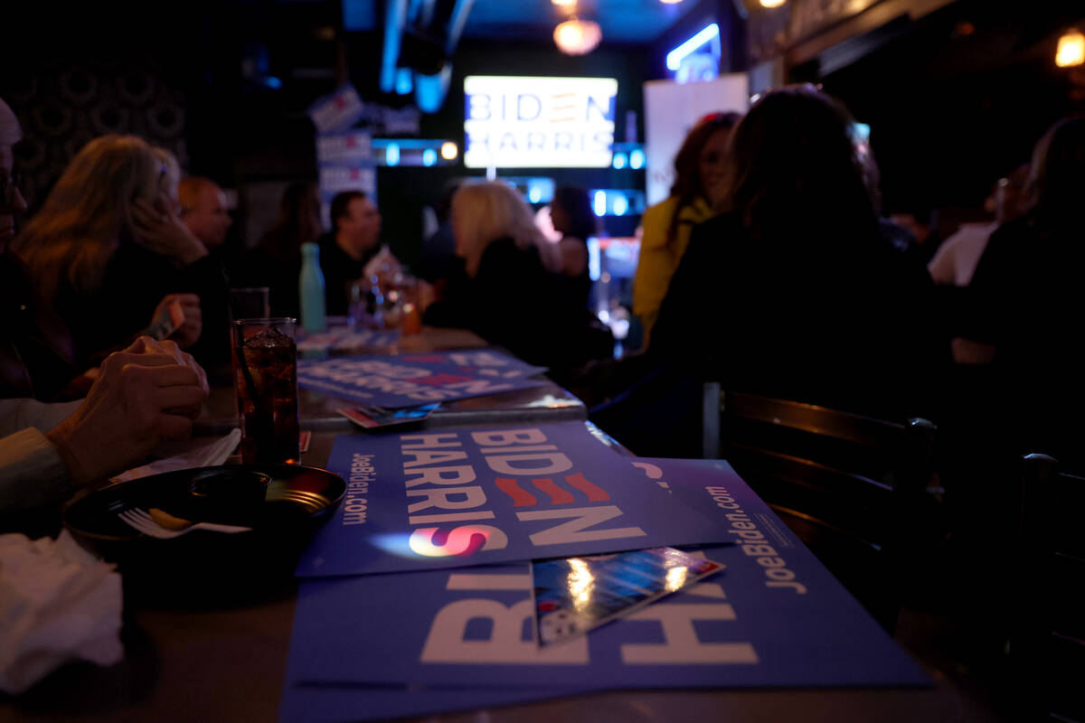 Biden-Harris campaign signs fill tables during a celebration after polls in the primary prefere ...
