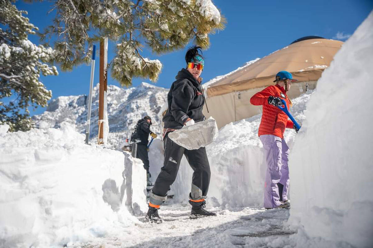 Shovelers remove feet of snow around buildings at Lee Canyon on Wednesday, Feb. 7, 2024. (Lee C ...