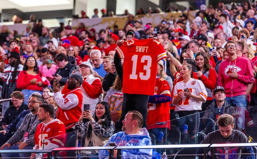 A fan holds up a Taylor Swift jersey in the stands during the Super Bowl Opening Night celebrat ...