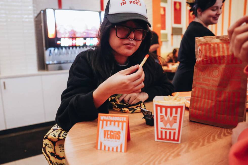 Anna L., a tourist from Dallas, Texas, eats a fry at Whataburger on Wednesday, Feb. 7, 2024, in ...