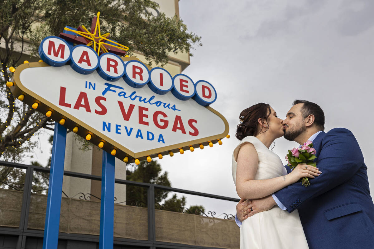 Louise, left, and Erkan Kaya, from Glasgow, Scotland, pose for a photo in front of the wedding- ...