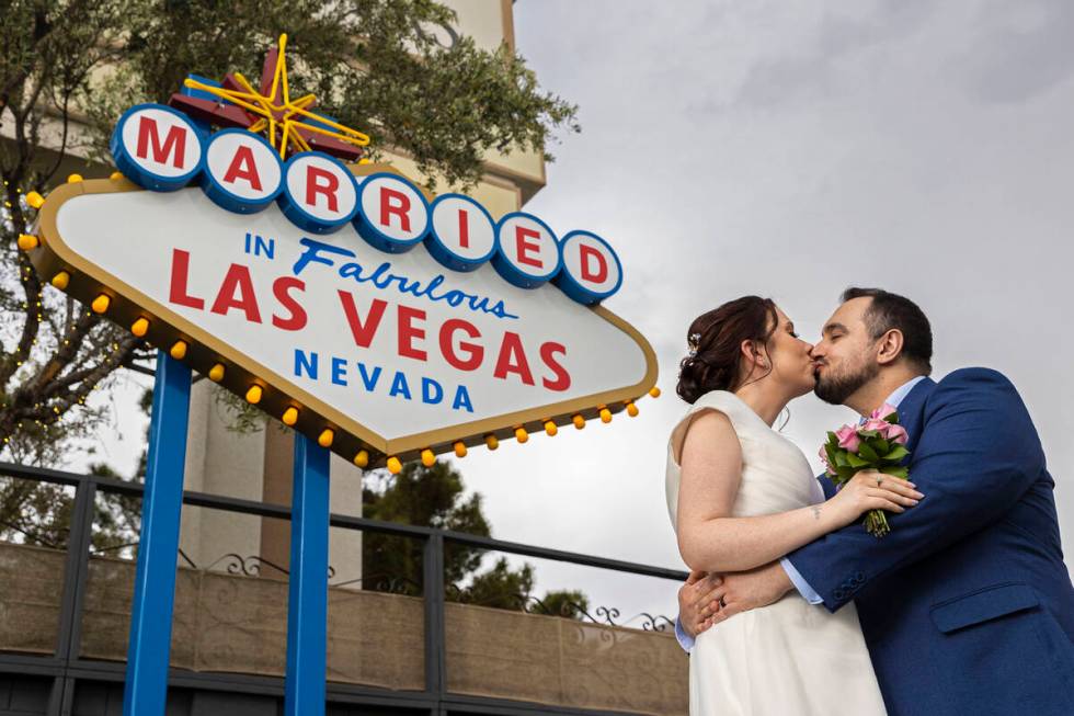 Louise, left, and Erkan Kaya, from Glasgow, Scotland, pose for a photo in front of the wedding- ...