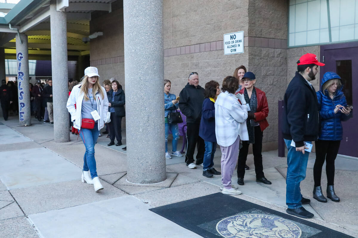 Voters wait in line to vote at a caucus center located at Sig Rogich Middle School in Summerlin ...