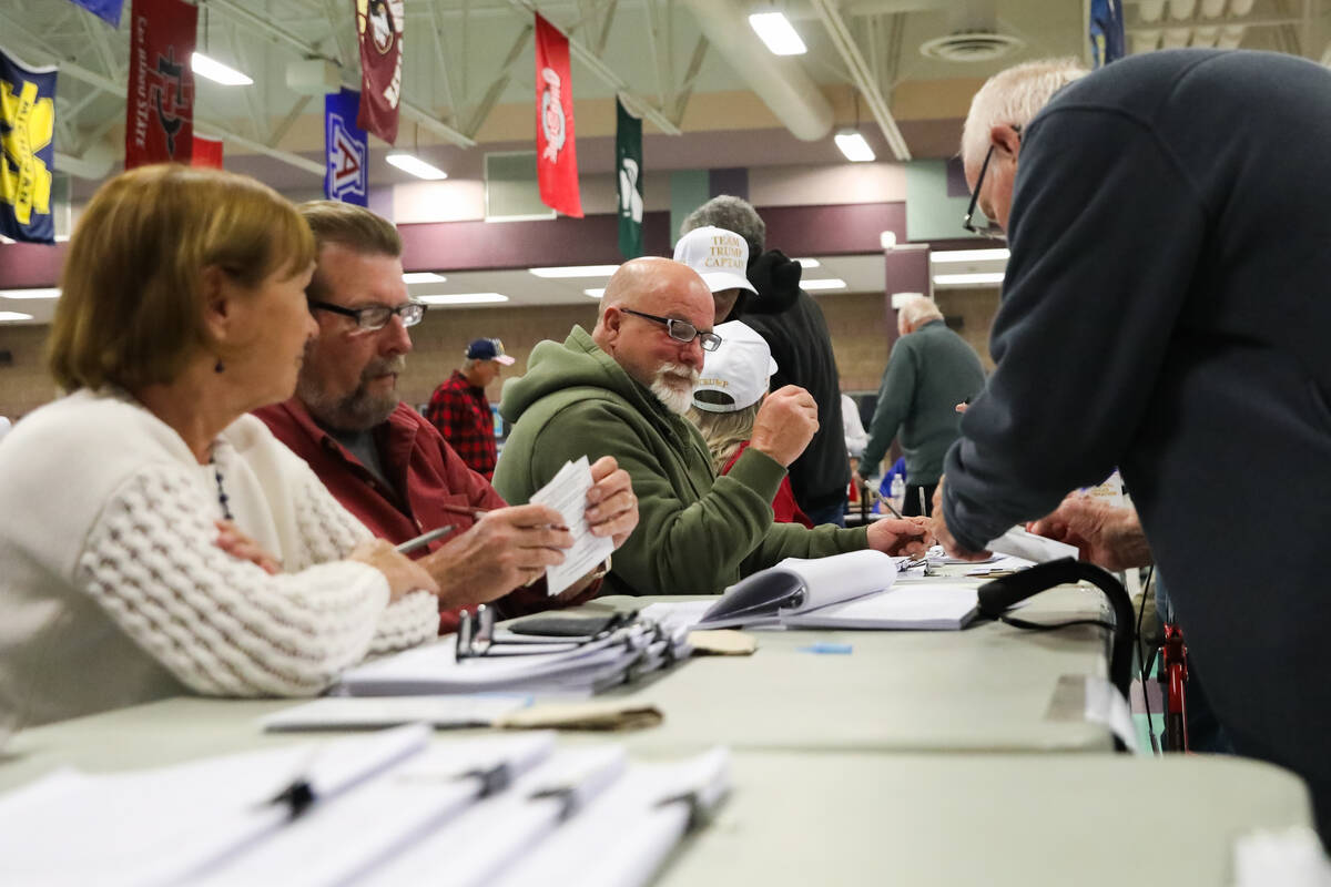 Voters sign in to vote at a caucus center located at Sig Rogich Middle School in Summerlin duri ...