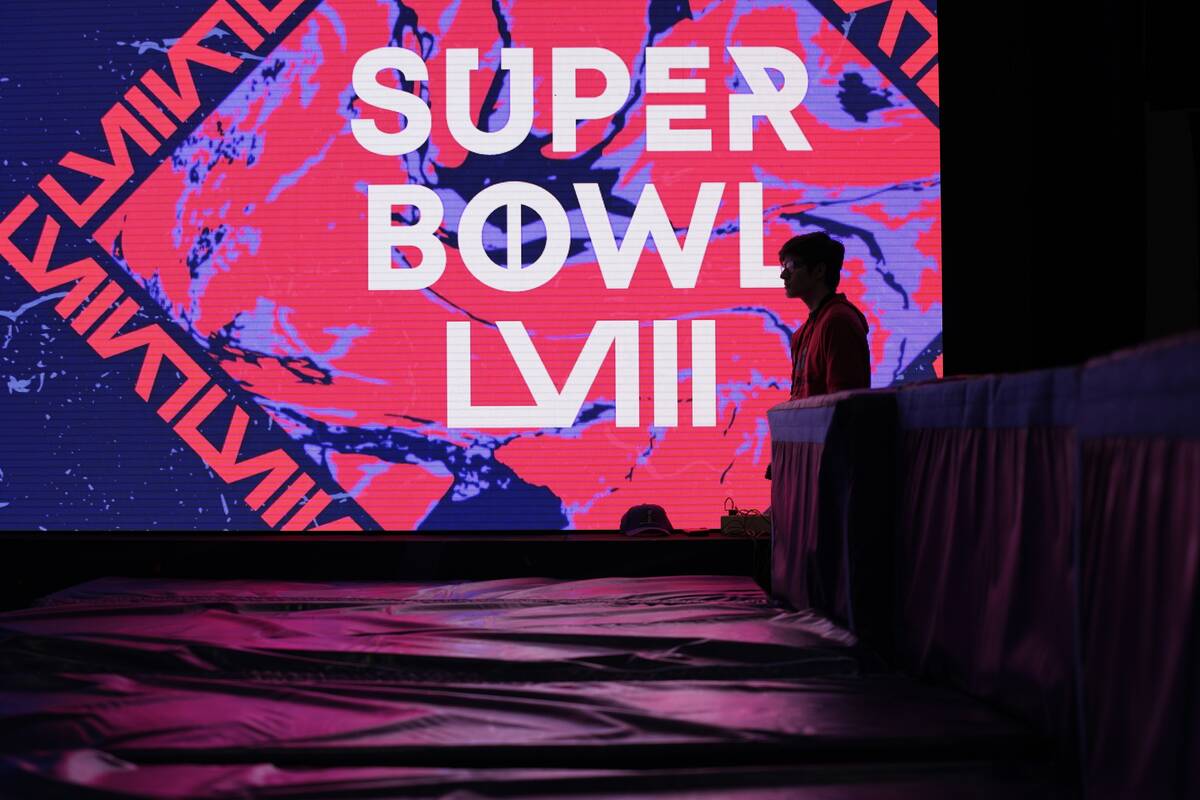 A worker stands by an exhibit at the Super Bowl Experience ahead of the Super Bowl 58 NFL footb ...