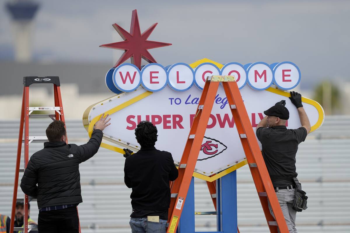 Workers prepare a welcome to Las Vegas sign in preparation of team arrivals ahead of the NFL Su ...