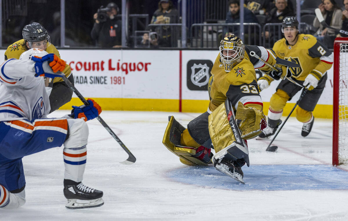 Golden Knights goaltender Adin Hill (33) deflects a shot on goal by Edmonton Oilers center Ryan ...