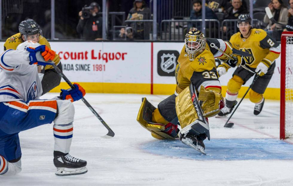 Golden Knights goaltender Adin Hill (33) deflects a shot on goal by Edmonton Oilers center Ryan ...