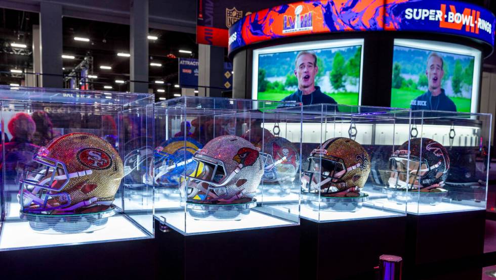 Helmets are all covered in crystals on display during the Super Bowl Experience at the Mandalay ...