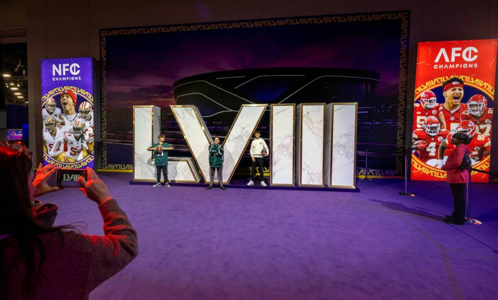 Fans pose for a photo at a numbers display during the Super Bowl Experience at the Mandalay Bay ...