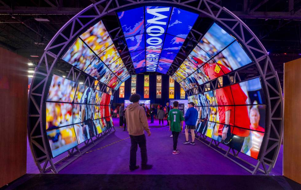 Fans walk through a video archway during the Super Bowl Experience at the Mandalay Bay Conventi ...