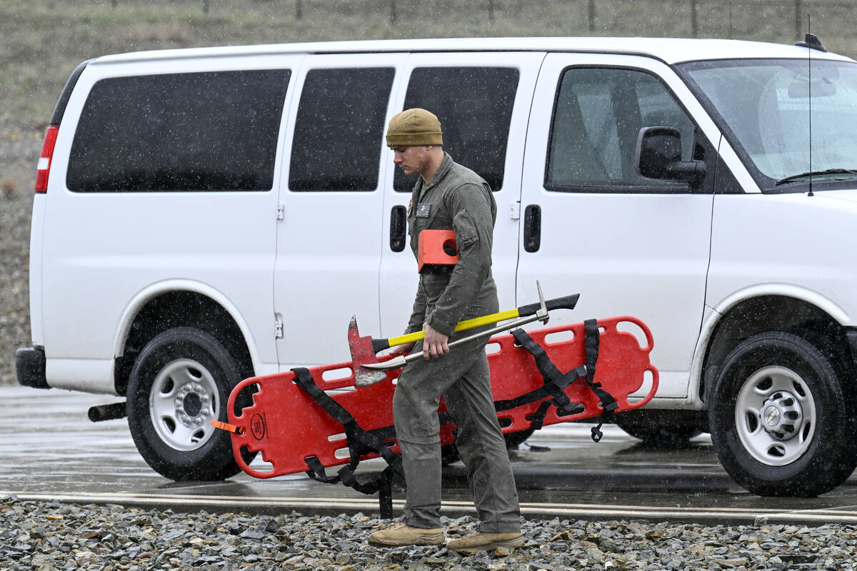 A U.S. Marine carries rescue gear at a command center Wednesday, Feb. 7, 2024, in Kitchen Creek ...