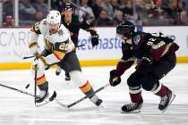 Vegas Golden Knights center Chandler Stephenson skates by Arizona Coyotes center Logan Cooley ( ...