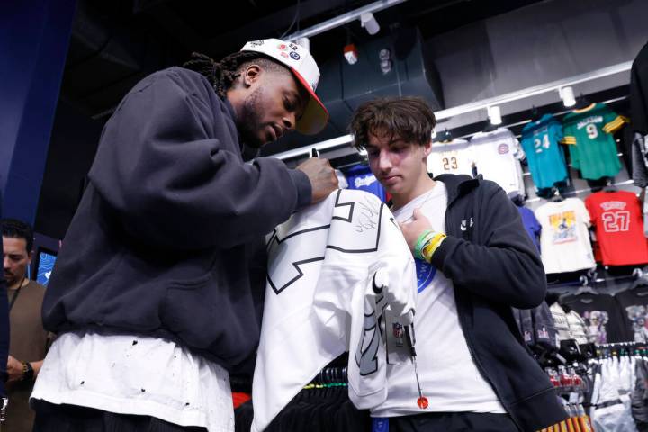 Raiders wide receiver Davante Adams signs an autograph to Judah Papa at the Lids Flagship Store ...