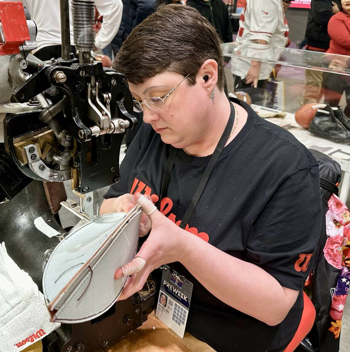Ashley Lamb, 36, who works at the Wilson Football Factory in Ada, Ohio, demonstrates how she se ...