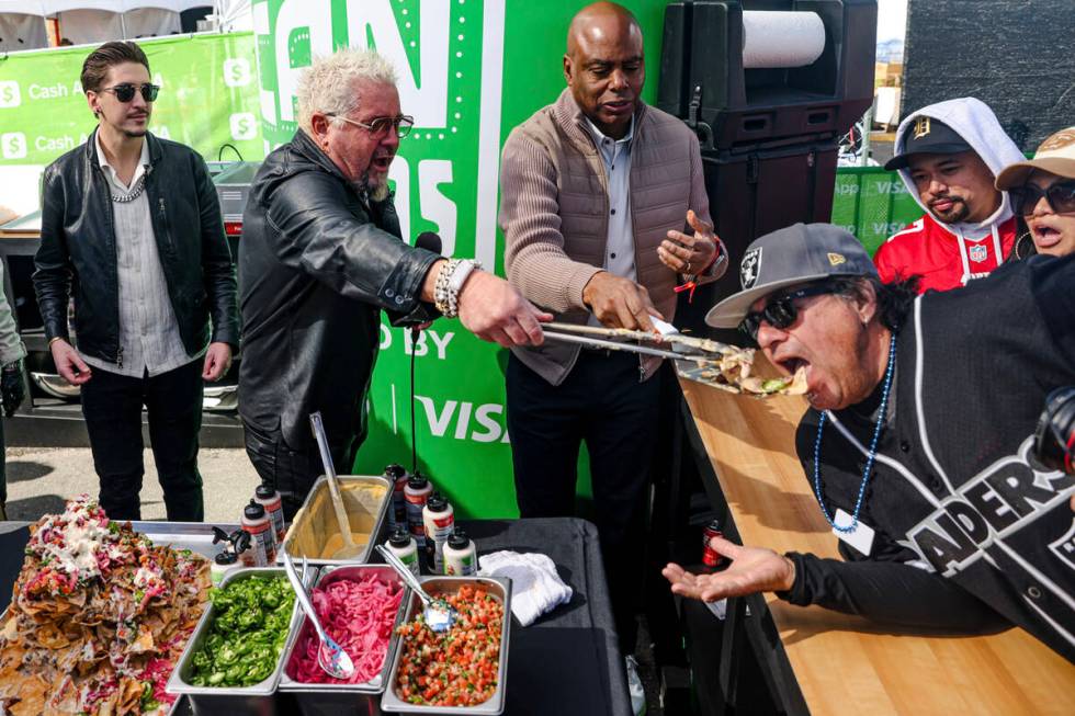 Celebrity chef Guy Fieri feeds a serving of trash can nachos to David Ortiz, from Los Angeles, ...