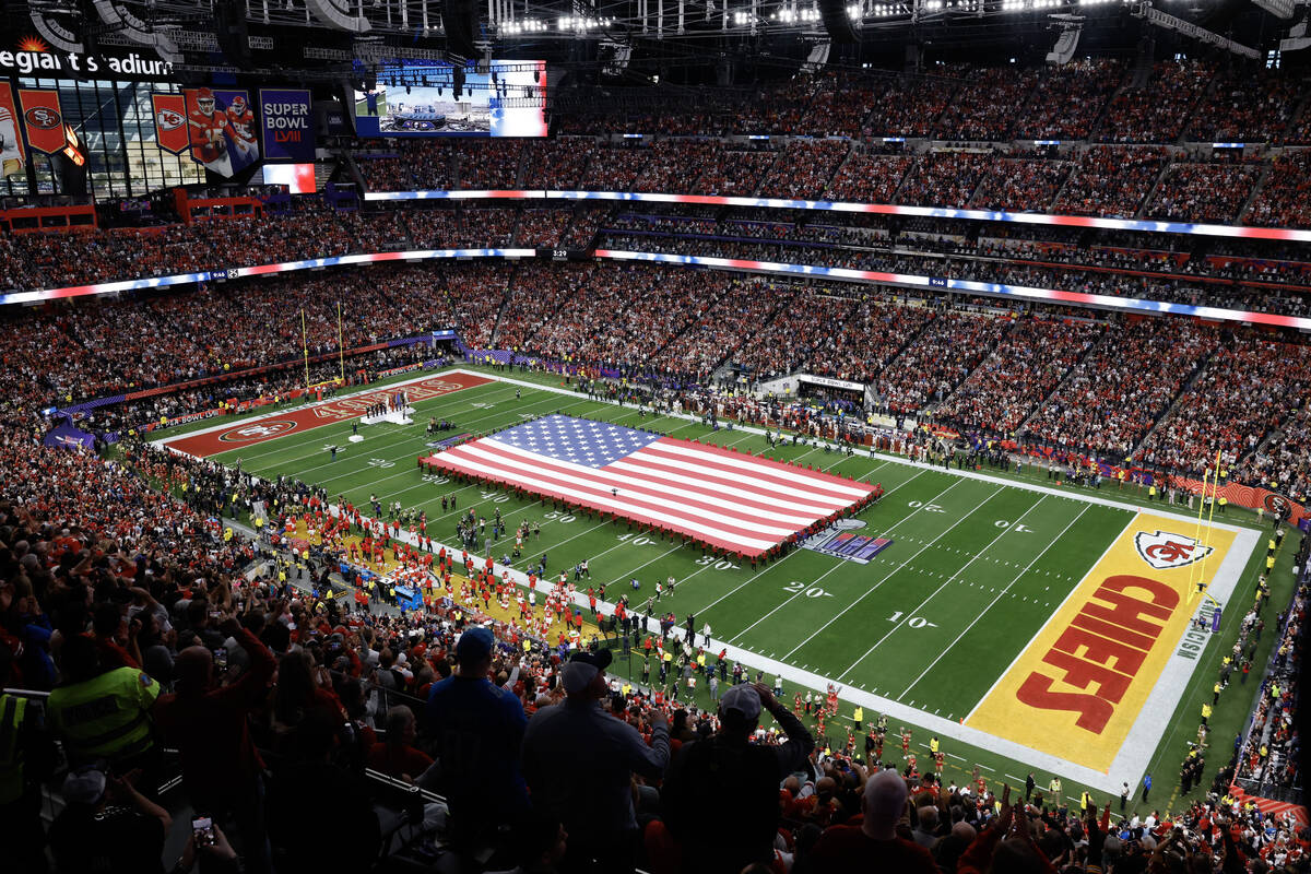 A United States flag is stretched over the field before Super Bowl 58 Sunday, February 11, 2024 ...