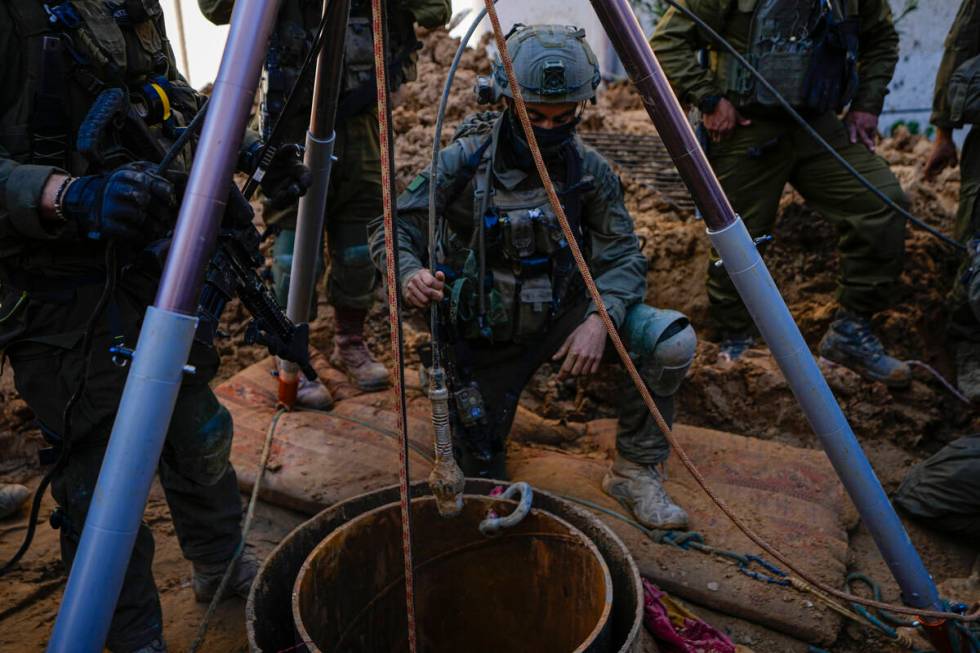 An Israeli soldier slides a camera down a hole inside the UNRWA compound courtyard where the mi ...