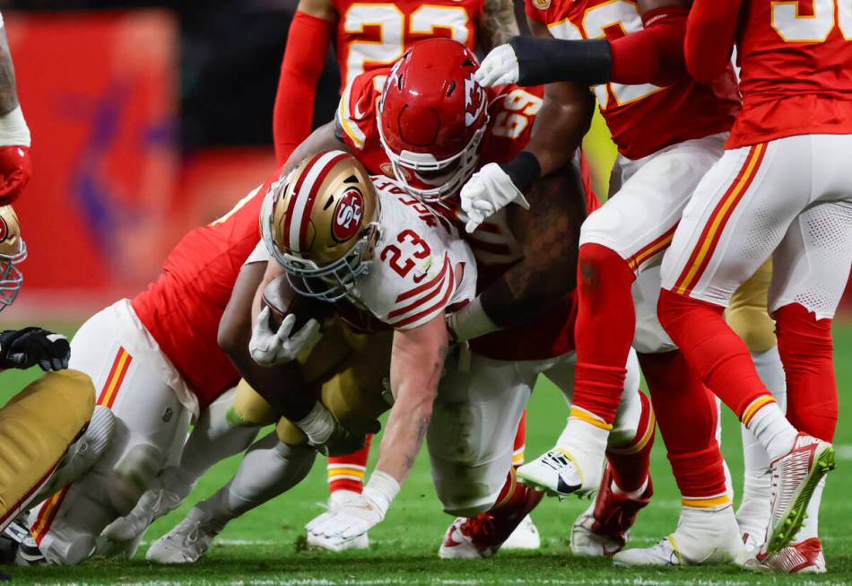 San Francisco 49ers running back Christian McCaffrey (23) gets tackled by Kansas City Chiefs de ...