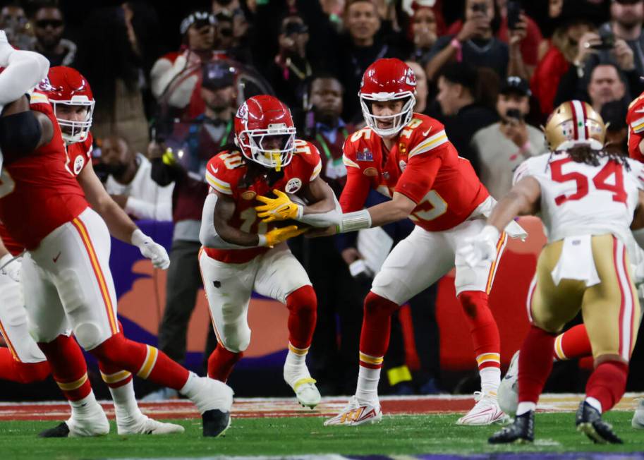 Kansas City Chiefs quarterback Patrick Mahomes (15) hands the ball off to Kansas City Chiefs ru ...