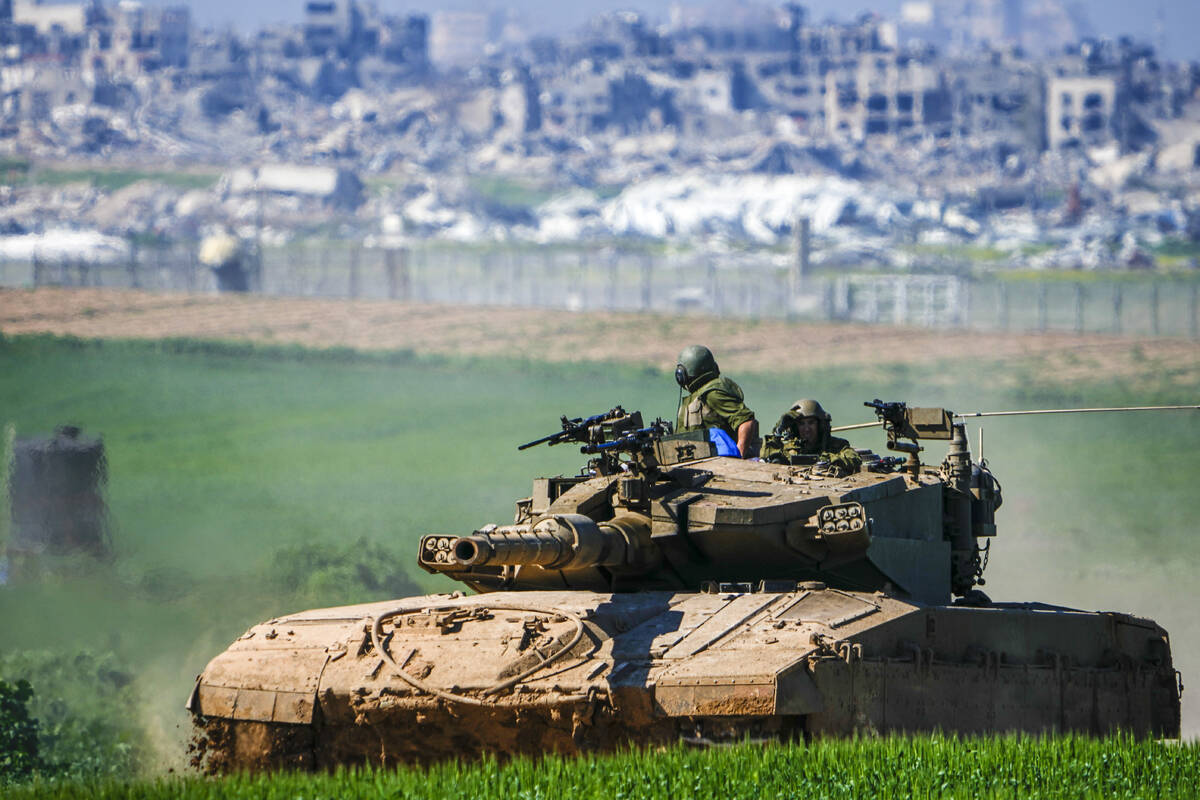 Israeli soldiers drive a tank on the border with the Gaza Strip, as seen in southern Israel, Su ...
