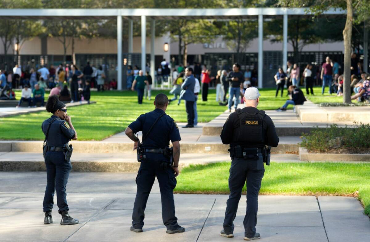 Houston Police officers watch over displaced churchgoers outside Lakewood Church, Sunday, Feb. ...