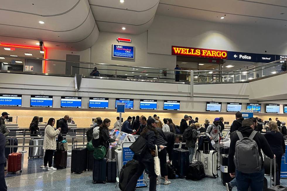 Travelers make their way through Harry Reid International Airport on Monday, Feb. 12, 2024, in ...