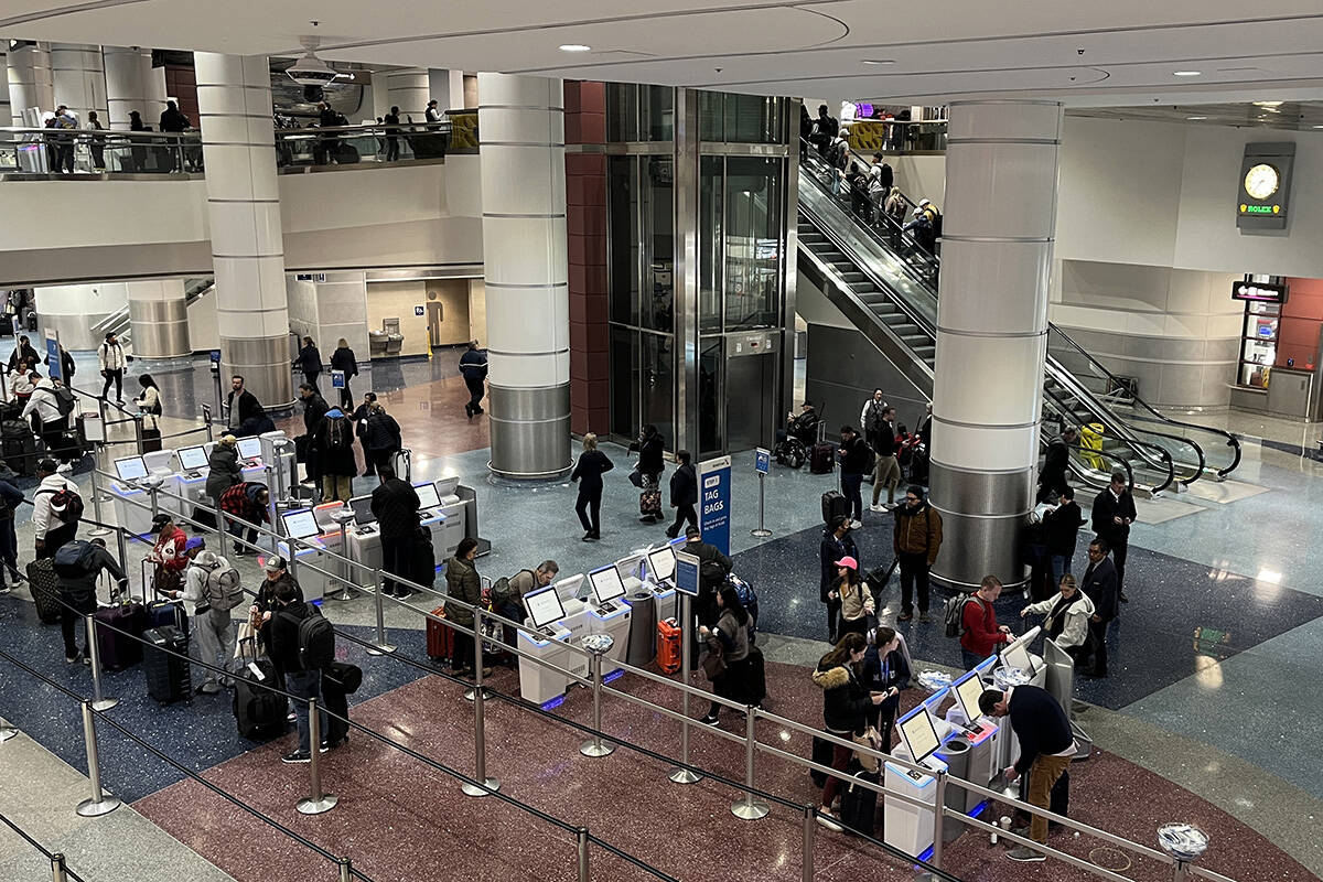 Travelers make their way through Harry Reid International Airport on Monday, Feb. 12, 2024, in ...