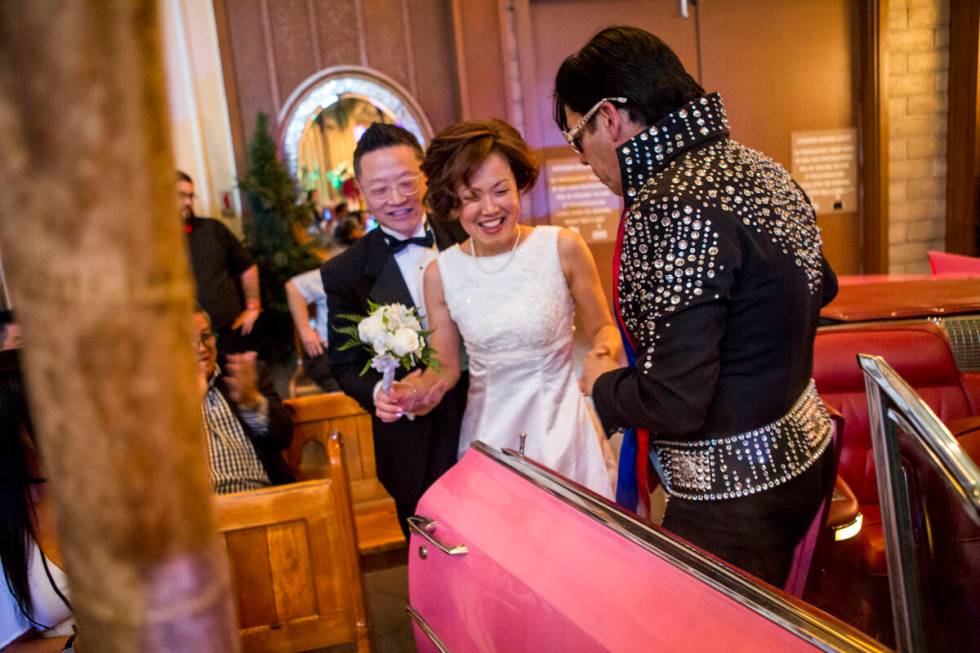 Ron Decar, owner of Viva Las Vegas, helps Julie and Garry Kim out of the pink Cadillac and into ...