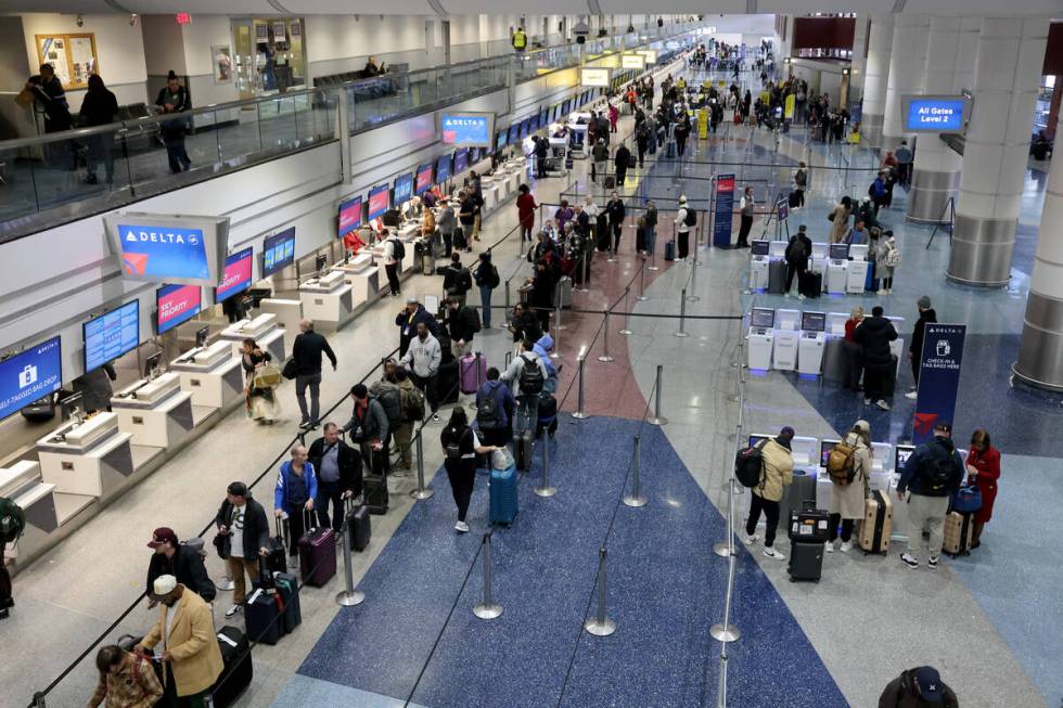 Travelers check their bags a Harry Reid International Airport on Monday, Feb. 12, 2024, a day a ...