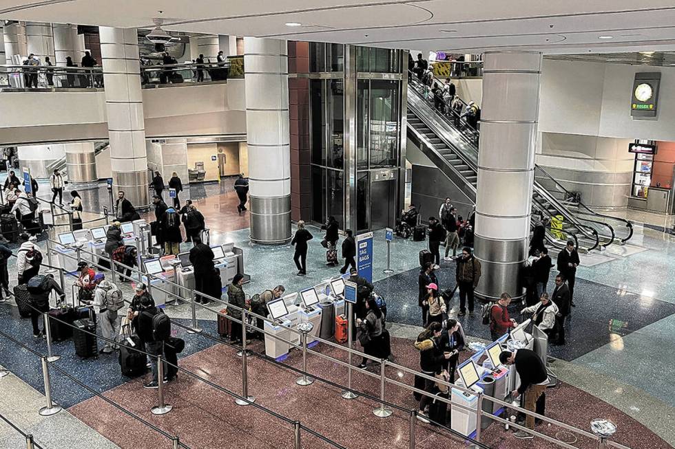 Travelers make their way through Harry Reid International Airport on Monday, Feb. 12, 2024, in ...