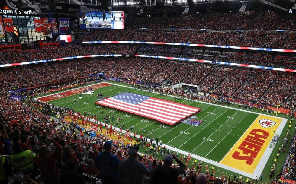 A United States flag is stretched over the field before Super Bowl 58 Sunday, Feb. 11, 2024, at ...