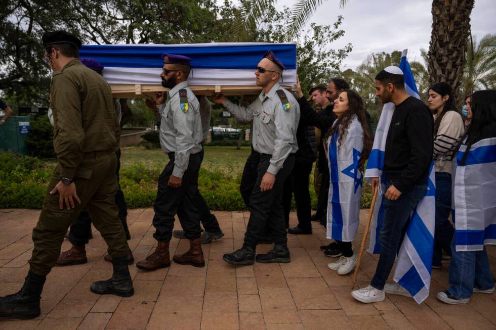 Family members of Israeli reservist Yair Cohen follow his flag-draped casket during his funeral ...