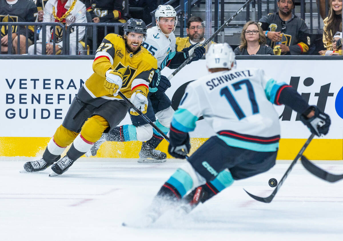 Golden Knights defenseman Shea Theodore (27) passes the puck past Seattle Kraken center Jaden S ...