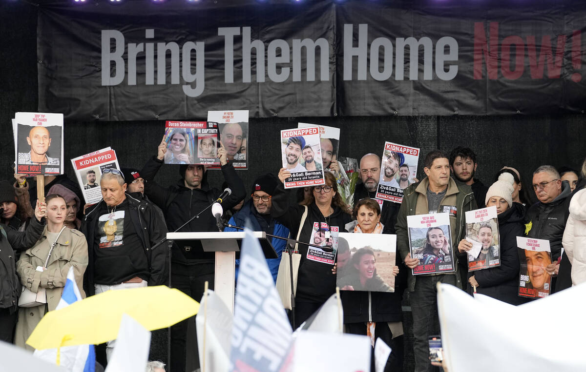 Families of hostages and former hostages hold images of the victims on a podium near the Intern ...