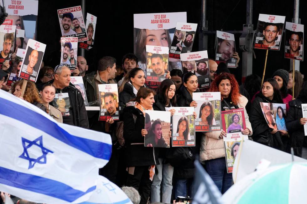 Families of hostages and former hostages hold images on a podium at a protest near the Internat ...