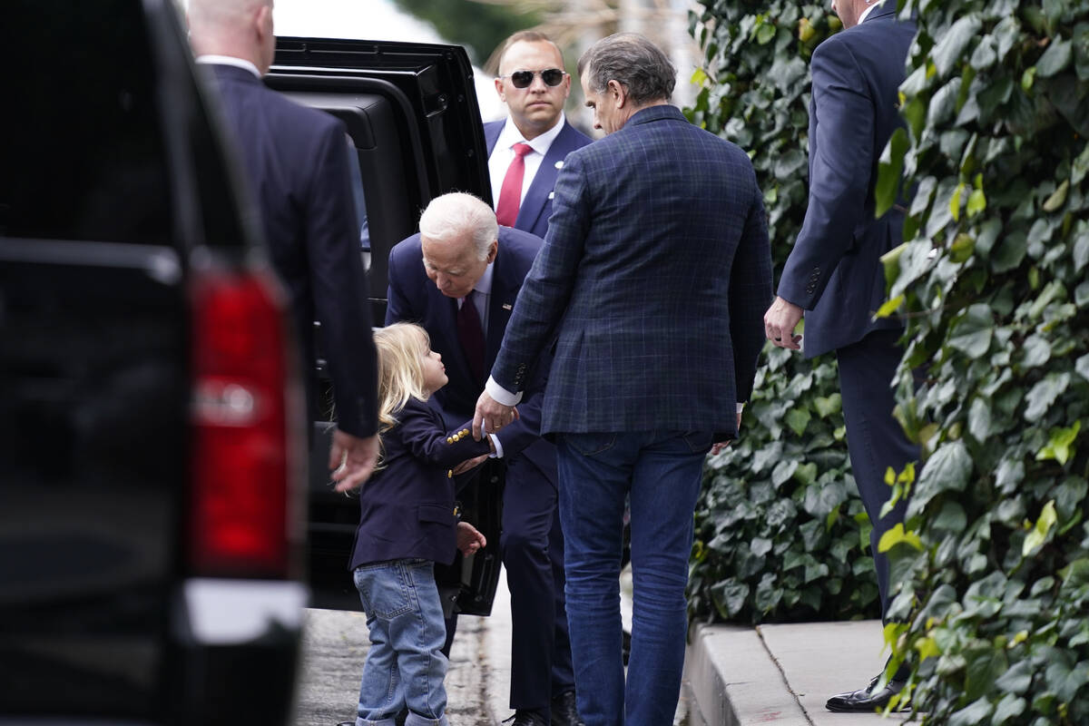 President Joe Biden, center, talks to his grandson Beau, left, as son Hunter Biden, right, look ...