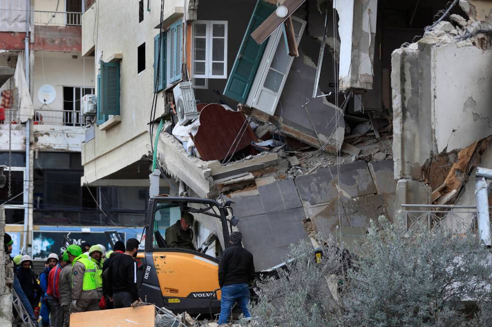 Civil defence and rescue workers remove rubbles from a building that was attacked Wednesday nig ...