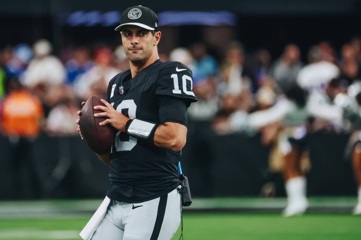Raiders quarterback Jimmy Garoppolo tosses a ball to a teammate during time out in the first ha ...