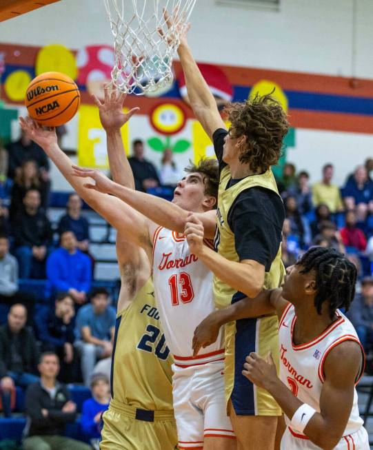 Bishop Gorman's Noah Westbrook (13) splits the defense of Foothill's Brock Stearman (20) and Co ...