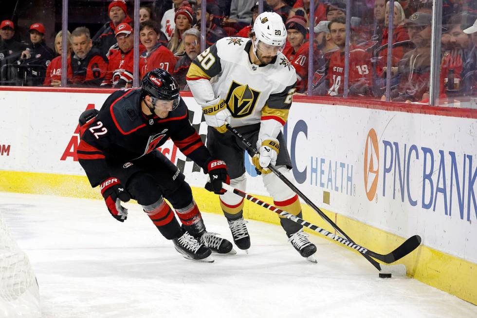 Carolina Hurricanes' Brett Pesce (22) battles for the puck with Vegas Golden Knights' Chandler ...