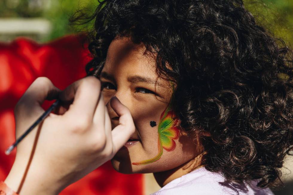 Abigail Snead, 5, has a butterfly painted onto her face at a facepainting booth at the Springs ...